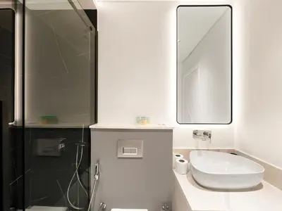 a white bathroom with a sink and a mirror at Huge Lux 1BHK in Prime Business Bay with Private Jacuzzi in Dubai