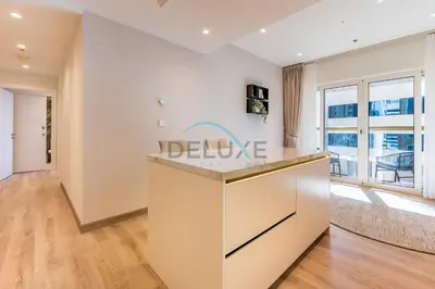 a kitchen with a large island in a room with a window at Upgraded 2BR with Partial Sea View Near to Dubai Tram, Elite Residence, Dubai Marina by Deluxe Holiday Homes in Dubai