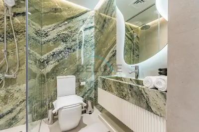 a bathroom with a toilet and a glass shower at Upgraded 2BR with Partial Sea View Near to Dubai Tram, Elite Residence, Dubai Marina by Deluxe Holiday Homes in Dubai
