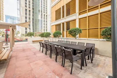a black dining table and chairs on a patio at Upgraded 2BR with Partial Sea View Near to Dubai Tram, Elite Residence, Dubai Marina by Deluxe Holiday Homes in Dubai