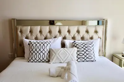 a bed with white pillows and a stuffed animal on it at Nivis find-Burj Vista-Direct access to Dubai mall in Dubai