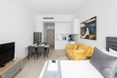 a living room with a bed and a dining room at Luma Studio in Jumeirah Village Circle in Dubai