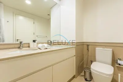 a bathroom with a toilet and a sink and a mirror at Balcony Overlooking the Swimming Pool, Just Minutes from the Park, Town Square Safi 1A, Al Yelayiss 2 by Deluxe Holiday Homes in Dubai