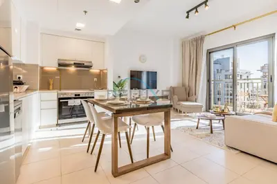 a kitchen and living room with a table and chairs at Balcony Overlooking the Swimming Pool, Just Minutes from the Park, Town Square Safi 1A, Al Yelayiss 2 by Deluxe Holiday Homes in Dubai