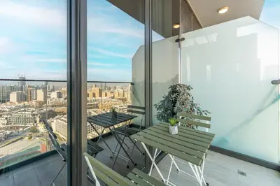 a balcony with a table and chairs and a view of the city at HAVN - New Studio Apartment in Bloom Towers, JVC in Dubai