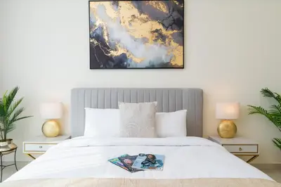 a bedroom with a white bed with two lamps at Classy Upgraded High Floor Prime Location in Dubai