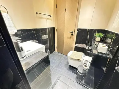 a bathroom with a shower and a toilet and a sink at Bright Studio Burj Khalifa & Canal Views Pool in Dubai