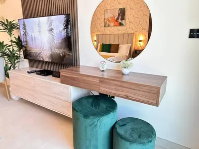 a living room with a tv and a mirror at Bright Studio Burj Khalifa & Canal Views Pool in Dubai