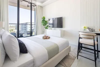 a hotel room with a bed and a desk and a window at Frank Porter - Samana Golf Avenue in Dubai