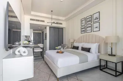 a bedroom with a large white bed and a table at Frank Porter - Samana Golf Avenue in Dubai