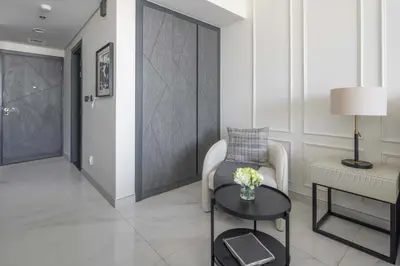 a living room with a chair and a table at Frank Porter - Samana Golf Avenue in Dubai
