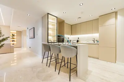 a kitchen with a bar with stools in it at Sea and Palm Jumeirah Views Just Steps from the Beach 2BR, Sadaf 6 , JBR by Deluxe Holiday Homes in Dubai