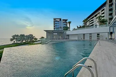a swimming pool in front of a building at Serene Seaside Stay - 2BR in Bluewaters with Sea View in Dubai