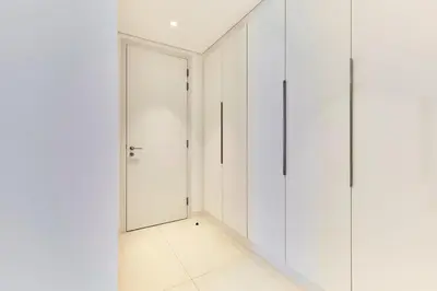 a white walk in closet with a glass door at Serene Seaside Stay - 2BR in Bluewaters with Sea View in Dubai