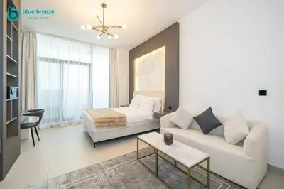 a living room with a couch and a bed at Blue Breeze - Trendy Studio with Balcony & Stylish Interiors in Dubai