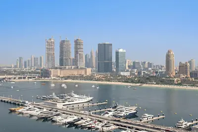 a group of boats docked in a harbor with a city at Silkhaus Waterfront 1BR in Marina Vista Tower in Dubai