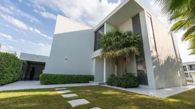 a white house with a palm tree in the yard at Lavish Sidra 3 Villa, 4BR plus M,Private Pool BBQ in Dubai