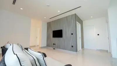 a living room with a couch and a tv on a wall at Lavish Sidra 3 Villa, 4BR plus M,Private Pool BBQ in Dubai