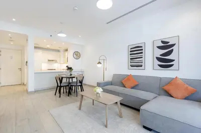 a living room with a couch and a table at Livbnb-Stylish 1B with Spacious Balcony in JVC in Dubai
