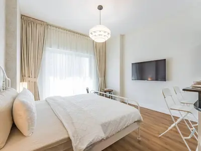 a bedroom with a bed and a table and a tv at Special Rate - Luxurious Studio - Golf View in Dubai