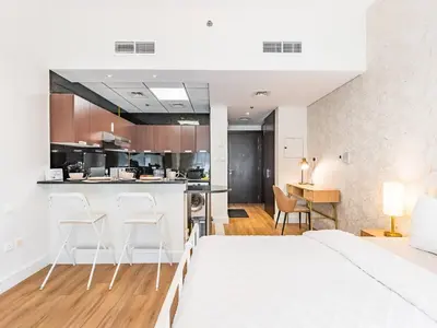 a bedroom with a large bed and a kitchen at Special Rate - Luxurious Studio - Golf View in Dubai