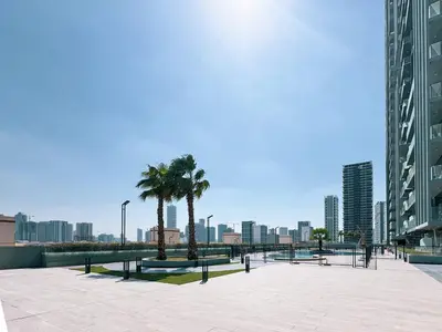 a large plaza with palm trees in a city at Stylish 1-Bedroom Apartment with Premium Amenities in Dubai