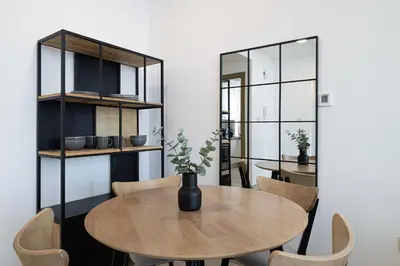 a dining room with a wooden table and chairs at Stylish 1-Bedroom Apartment with Premium Amenities in Dubai
