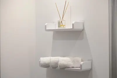 a white towel rack in a bathroom with towels at Stylish 1-Bedroom Apartment with Premium Amenities in Dubai