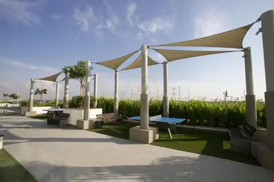 a row of benches with umbrellas in a park at Standard 2BHK located in Azizi riviera 46 in Dubai