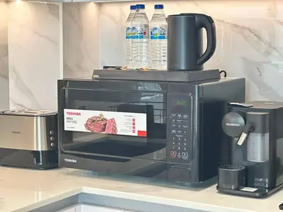 a microwave with a sign on the front of it at Comfortable 1br Jvc Balcony Parking in Dubai