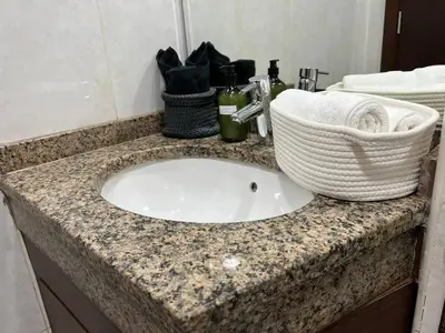 a bathroom counter with a sink with a basket and towels at Everything you need for a perfect Dubai Stay in Dubai