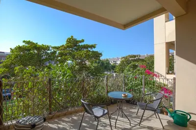 a patio with chairs and a table on a balcony at Spacious studio in a green oasis in Dubai