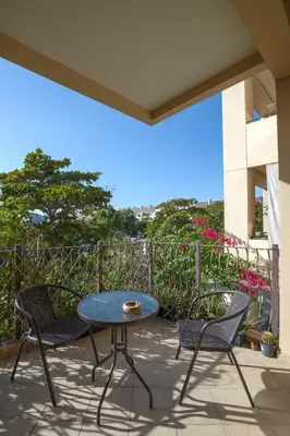 a patio with a table and chairs on a balcony at Spacious studio in a green oasis in Dubai