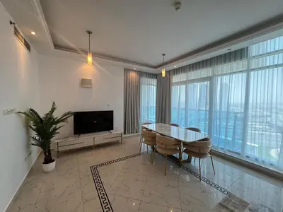 a dining room with a table and chairs and a television at Opal Tower, Marina in Dubai