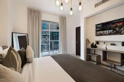 a bedroom with a large bed and a television at Breathtaking Views & Contemporary Comfort in the Heart of Downtown in Dubai