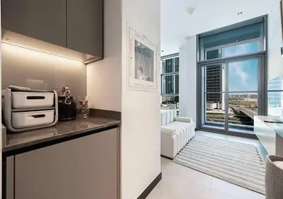 a kitchen with a view of a living room at Chic Studio with Top Amenities in Dubai
