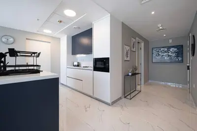 a large kitchen with white cabinets and a counter at Downtown Sanctuary Iconic Burj Views & Luxury Living in Dubai