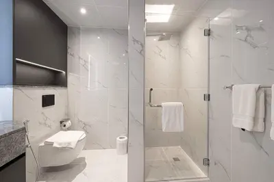 a bathroom with a toilet and a glass shower at Downtown Sanctuary Iconic Burj Views & Luxury Living in Dubai