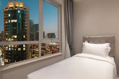 a bedroom with a window with a view of a city at Downtown Sanctuary Iconic Burj Views & Luxury Living in Dubai