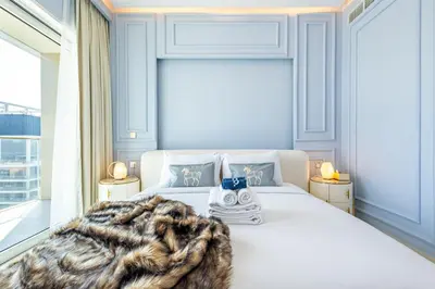 a bedroom with a large white bed with a blanket at Lux Designer 2BR - Grand Bleu - Waterfront Living in Dubai