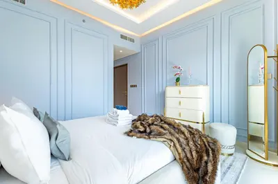 a cat laying on a bed in a room at Lux Designer 2BR - Grand Bleu - Waterfront Living in Dubai