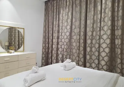 a bedroom with two folded towels on a bed at Elegant 2BR in Dubai Hills Estate Hosted by Desert City Stays in Dubai
