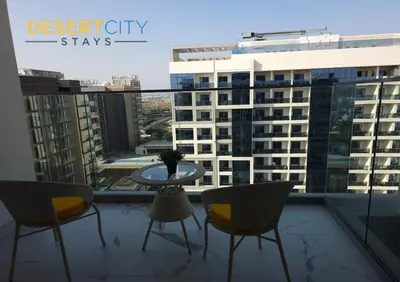 a balcony with chairs and a table and a view of a city at Elegant 2BR in Dubai Hills Estate Hosted by Desert City Stays in Dubai