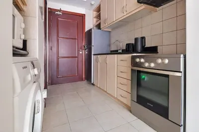 a kitchen with a stove and a refrigerator at 021 - Discovery Gardens (Building 18) in Dubai