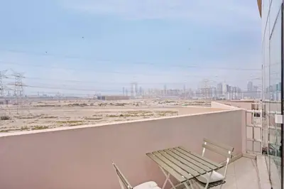 a balcony with a bench and a view of a city at 021 - Discovery Gardens (Building 18) in Dubai