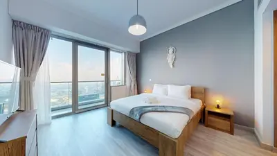 a bedroom with a bed and a large window at Ocean Heights - One Bed with City View of Marina in Dubai