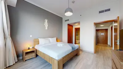 a bedroom with a large bed with white sheets at Ocean Heights - One Bed with City View of Marina in Dubai