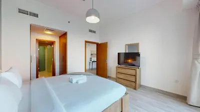 a bedroom with a bed and a flat screen tv at Ocean Heights - One Bed with City View of Marina in Dubai