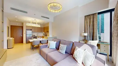 a living room with a couch and a kitchen at Act One Act Two - Exquisite One Bed in Downtown in Dubai