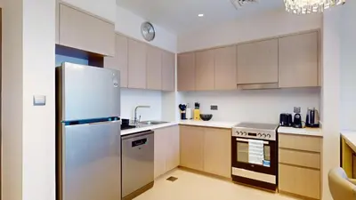a kitchen with a refrigerator and a sink at Act One Act Two - Exquisite One Bed in Downtown in Dubai